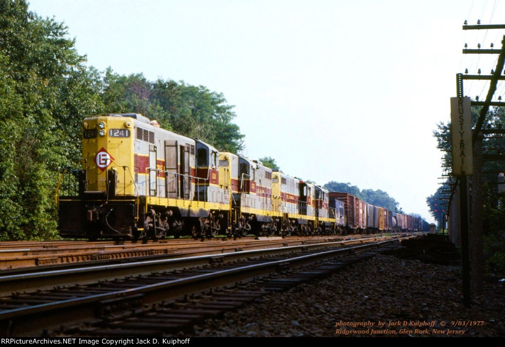 EL, Erie Lackawanna, GP7s 1241-1232-1239-1238 head eastbound down the ex-Erie mainline to make its setout and pickups at Paterson, NJ before heading back west to Suffern NY. We are at Ridgewood Jct, Glen Rock, New Jersey. September 3, 1977. 